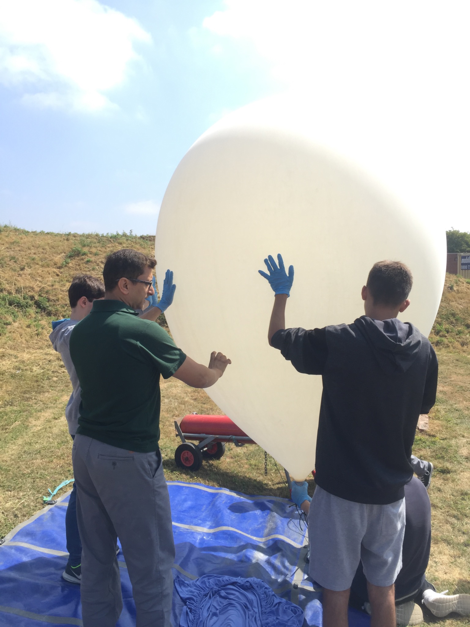 Mr. Roger and team members holding a large inflated balloon outdoors
